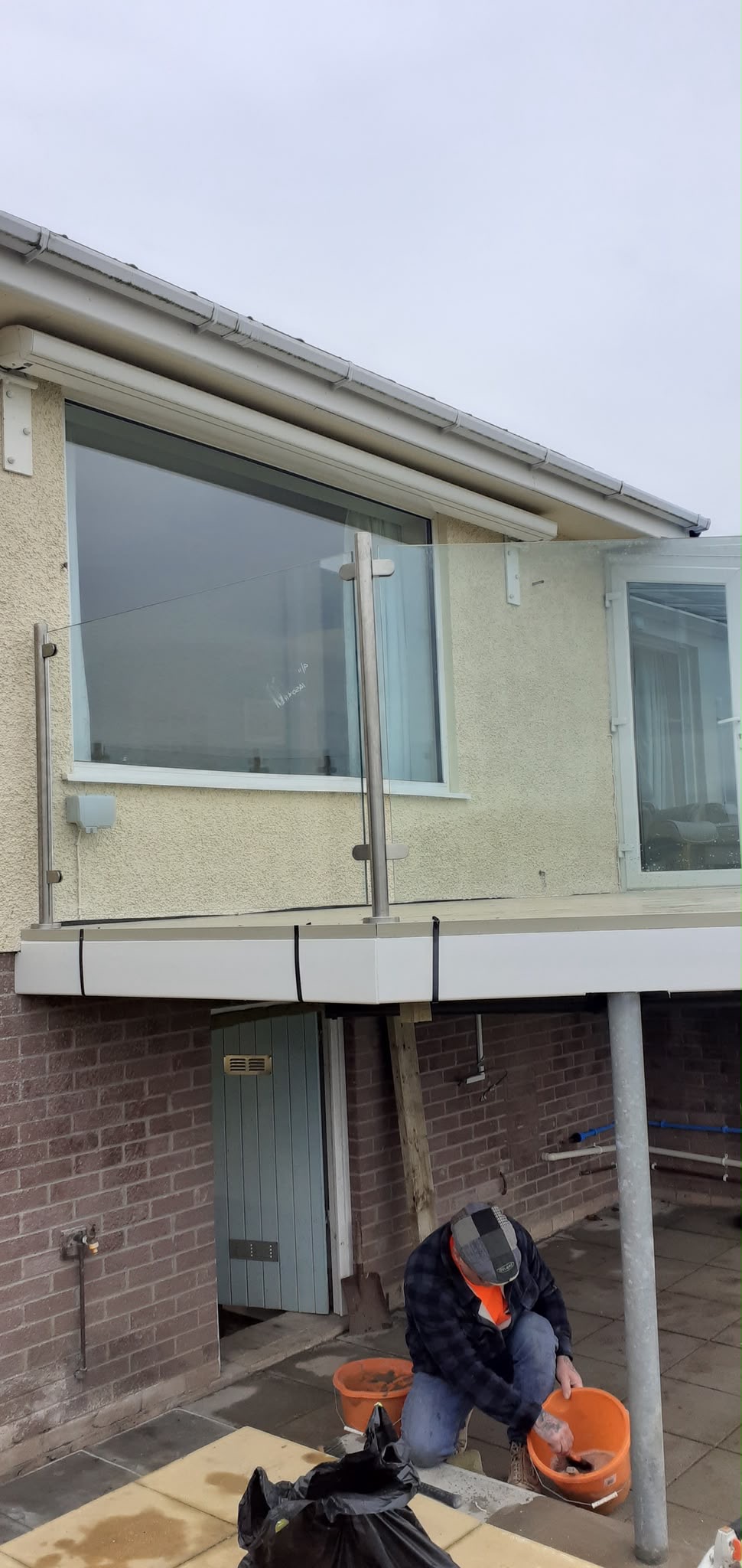 Elevated balcony composite deck with glass balustrade in North Wales