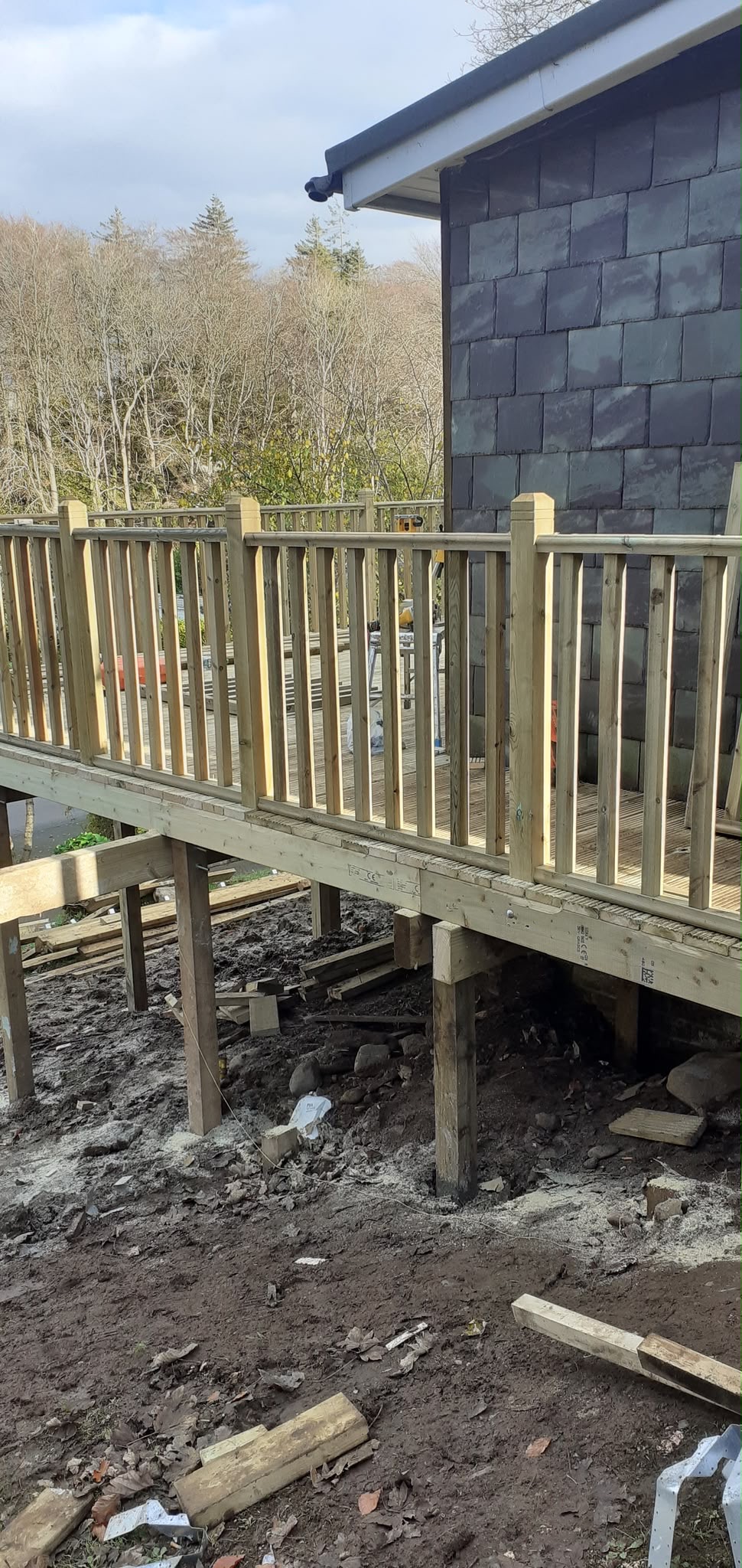 Raised timber deck on posts with wooden balustrade railing